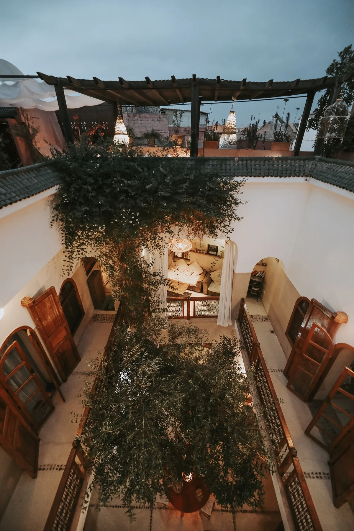 Evening from the rooftops — the patio lights up beneath the terrace pergola