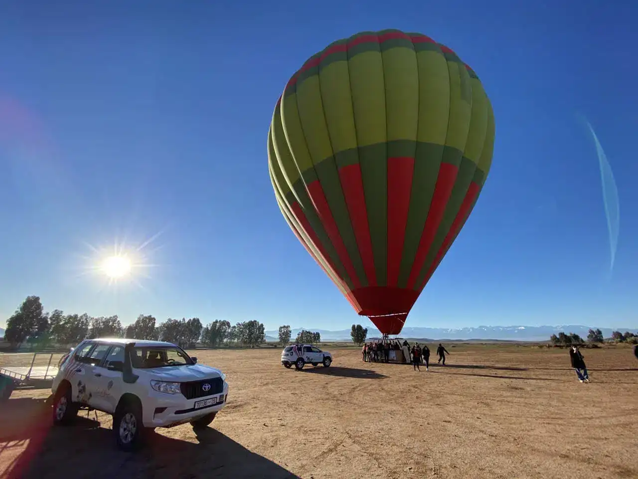 A hot-air balloon ready to rise at daybreak on the Marrakech plain, the Atlas range as a backdrop